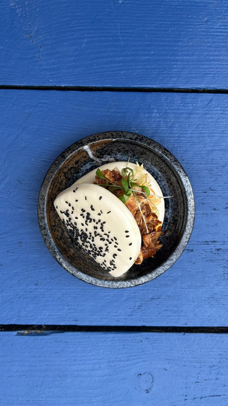 A Copper Fox bao bun served on a blue table